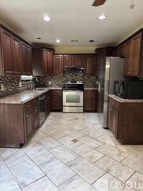 A kitchen with brown cabinets and a tile floor.