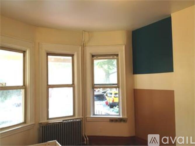 A room with two windows and a radiator on the wall.