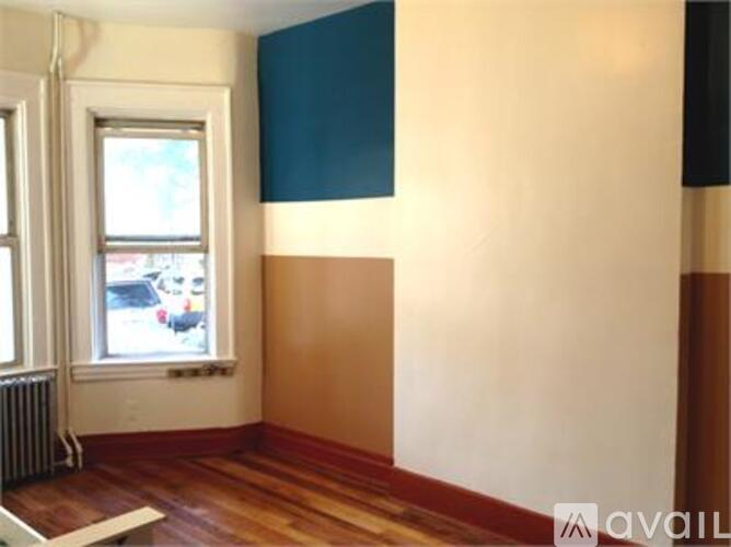 A room with a window and a radiator on the wall.