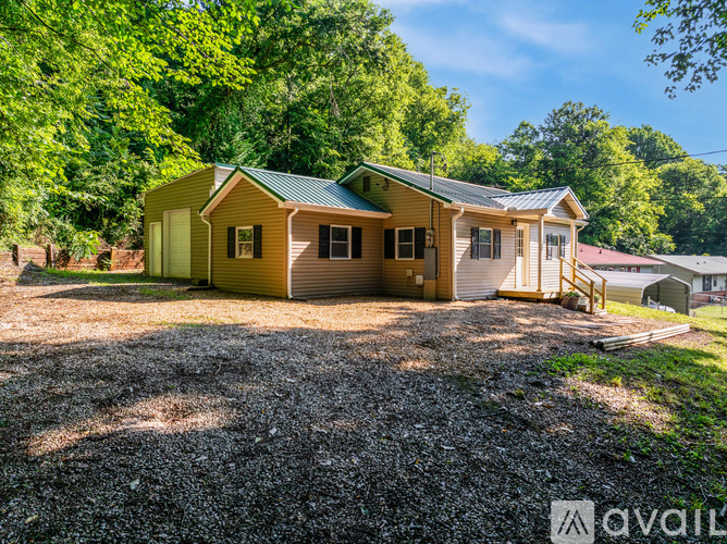 A house with a gravel driveway in front of it.