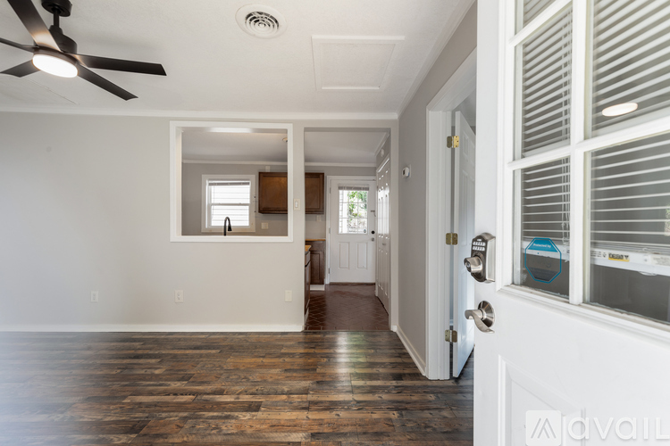 A room with a ceiling fan and a door leading to another room.