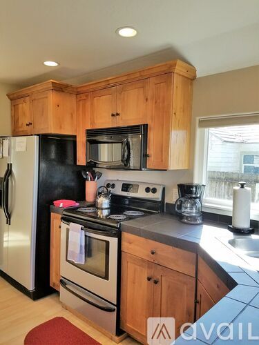 A kitchen with wooden cabinets and black appliances.