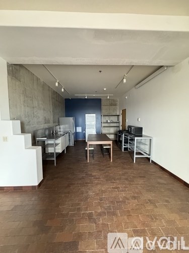 A kitchen with a dining table and chairs is visible.