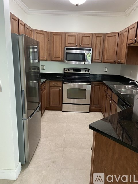 A kitchen with wooden cabinets and black countertops.