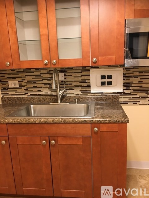 A kitchen with wooden cabinets and a granite countertop.