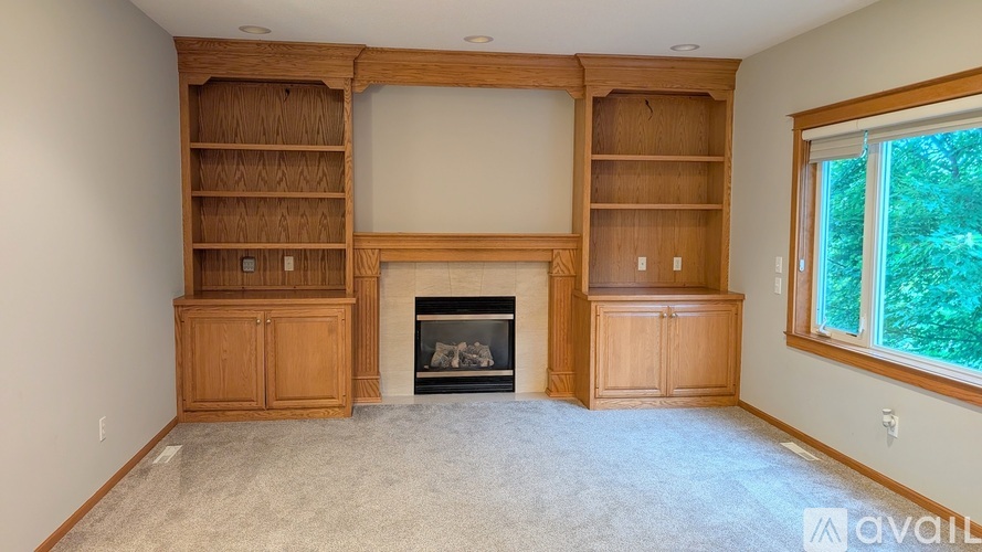 A living room with a fireplace and built-in shelves.
