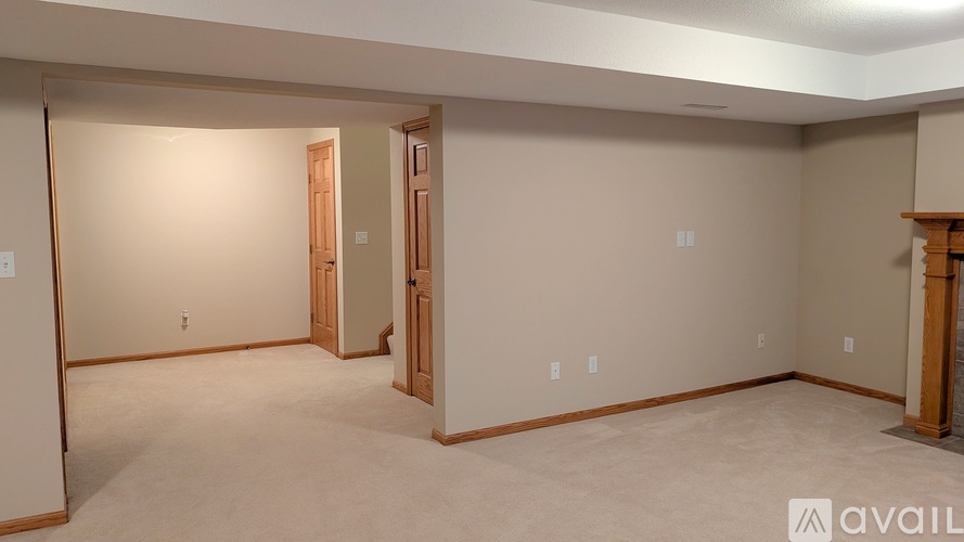 A spacious room with beige walls and carpeted floor.