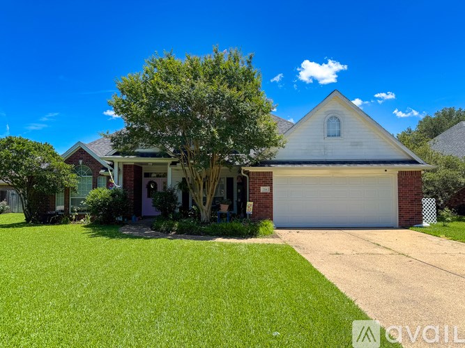 A house with a white garage door and a tree in front.