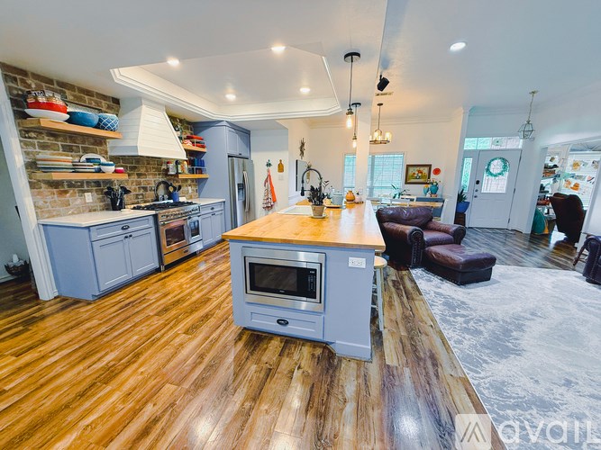 A kitchen with wooden floors and a large island in the middle.