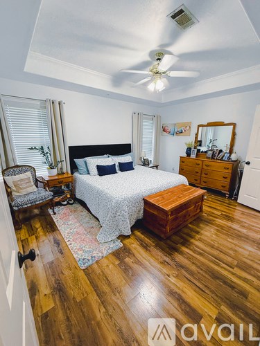 A bedroom with a bed, dresser, and mirror.