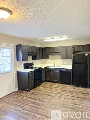A kitchen with black cabinets and a white countertop.