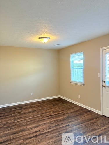 A room with a wooden floor and a window.