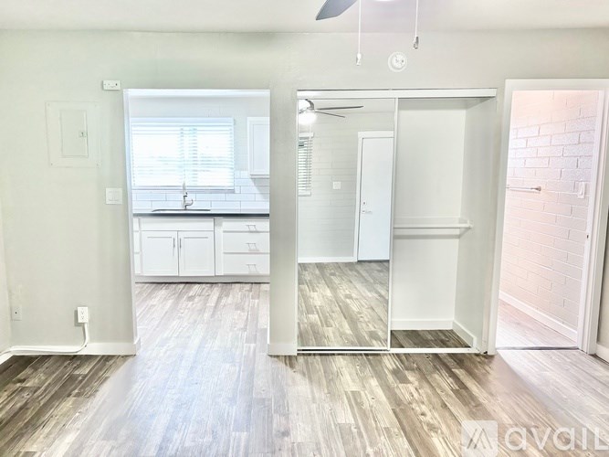 A room with a kitchen and a bathroom visible through the mirror.
