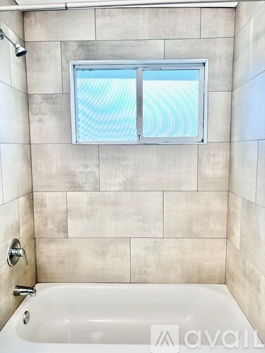 A bathroom with a tub and a window.