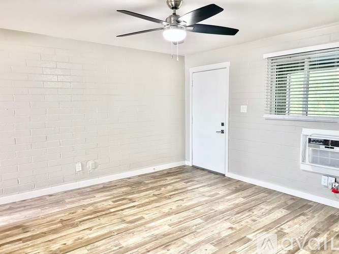 A room with a ceiling fan and a window with blinds.