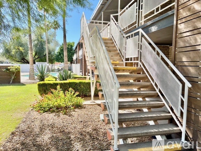 A set of stairs with a metal railing leads up to a building.
