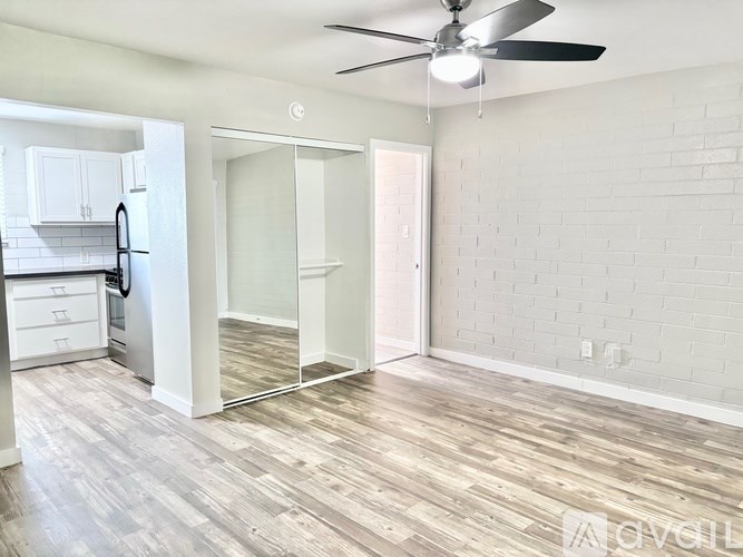 A room with a ceiling fan and a wooden floor.