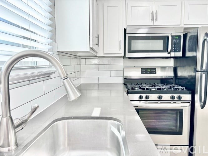 A kitchen with a stainless steel sink and a stove.