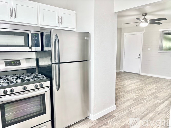 A kitchen with stainless steel appliances and white cabinets.