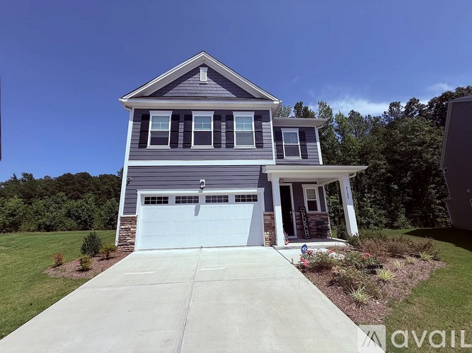 A two-story house with a garage is available for sale.