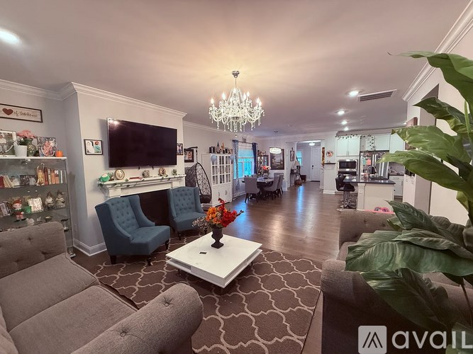 A living room with a grey sofa, a white coffee table, and a chandelier.