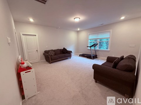 A living room with a brown couch and a white cabinet.