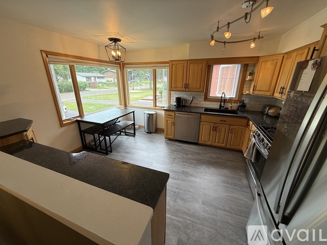 A kitchen with wooden cabinets and a black countertop.