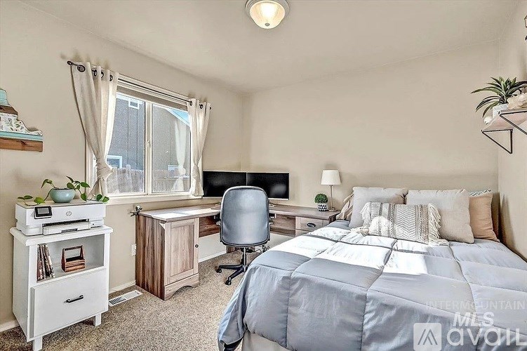 A bedroom with a bed, desk, and chair.