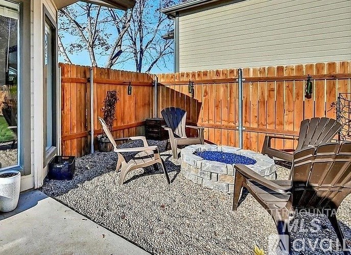 A backyard with a wooden fence and a small pool.