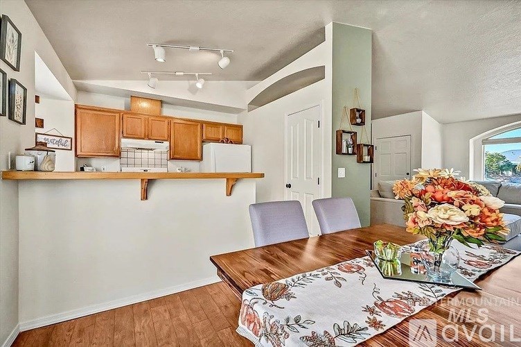 A kitchen with a table and chairs in the foreground.