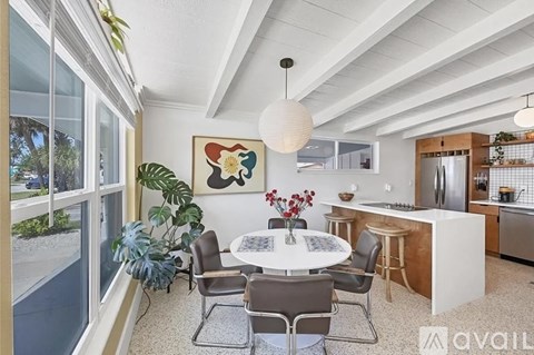 A modern kitchen with a dining table set up with chairs.