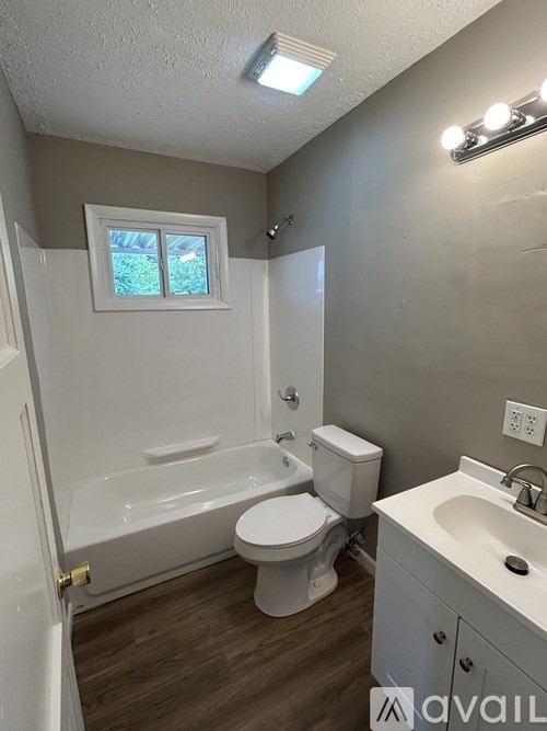A small bathroom with a toilet, sink, and bathtub.
