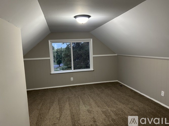 A room with a window and carpeted floor.