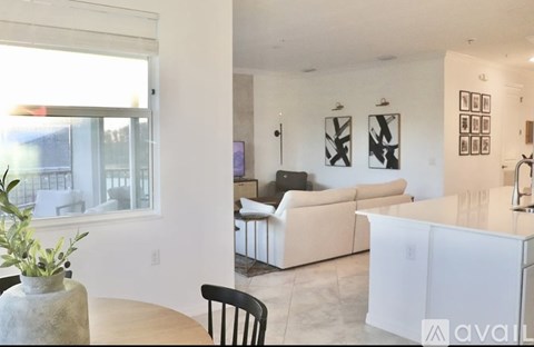 A living room with a white couch and a black chair.