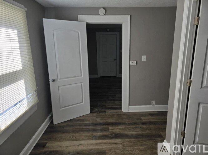 A room with a white door and a window with blinds.