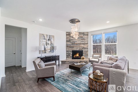 A modern living room with a fireplace and a large painting on the wall.