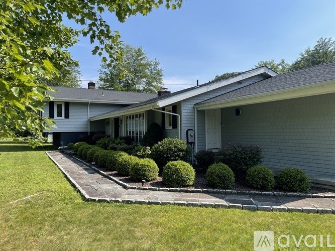 A house with a well-maintained lawn and a clear sky above.