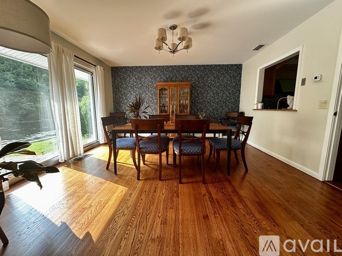 A dining room with a wooden table and chairs.