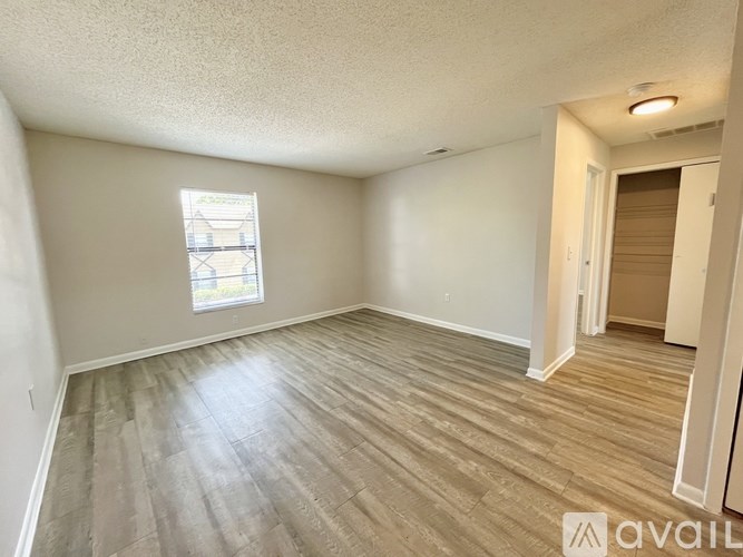 A kitchen with white appliances and brown floors.