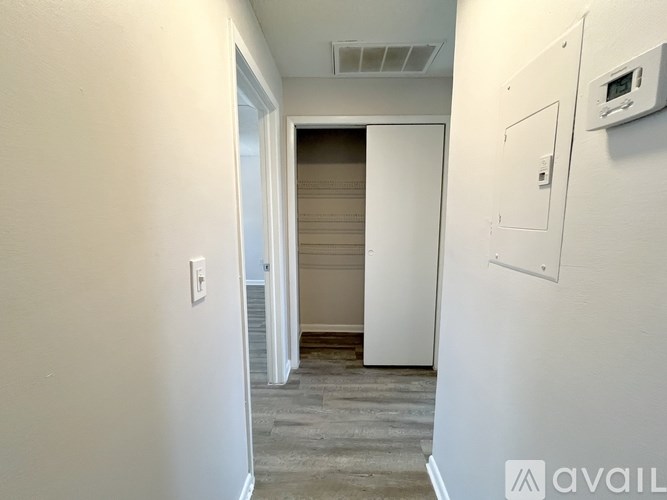A room with a poster on the wall and wooden flooring.