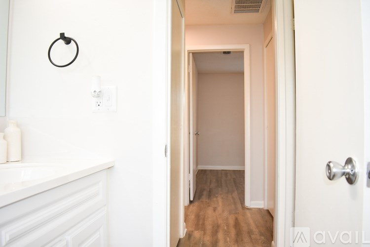 A room with a ceiling fan and wooden flooring.