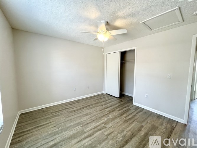 A bathroom with a white tub and a window with curtains.