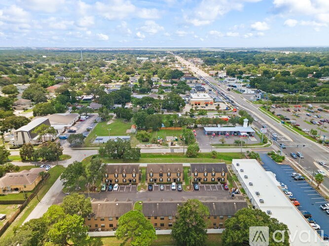 A bird's eye view of a residential area with apartment buildings, roads, and greenery.