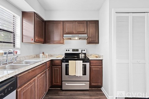 A kitchen with brown cabinets and a stove top oven.