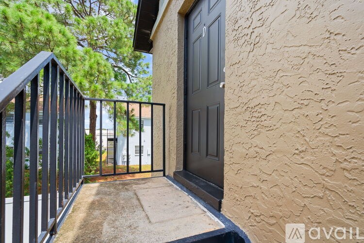 A balcony with a black railing and a black door.