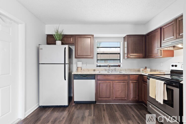 A kitchen with a white refrigerator and brown cabinets.