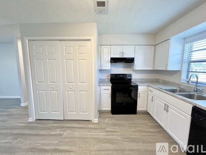 A room with a white door and a window with a view of a building.