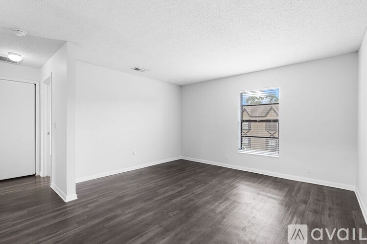 A room with wooden flooring and a picture of a house on the wall.