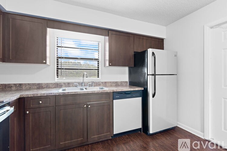 A kitchen with brown cabinets and a white fridge.