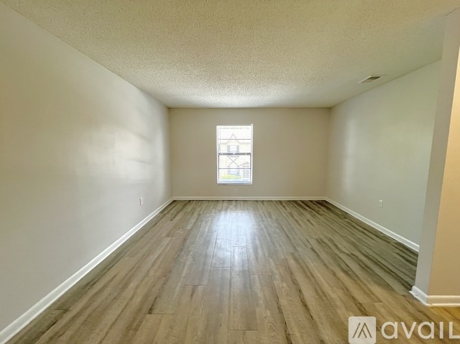 A kitchen with a white fridge and wooden floors.